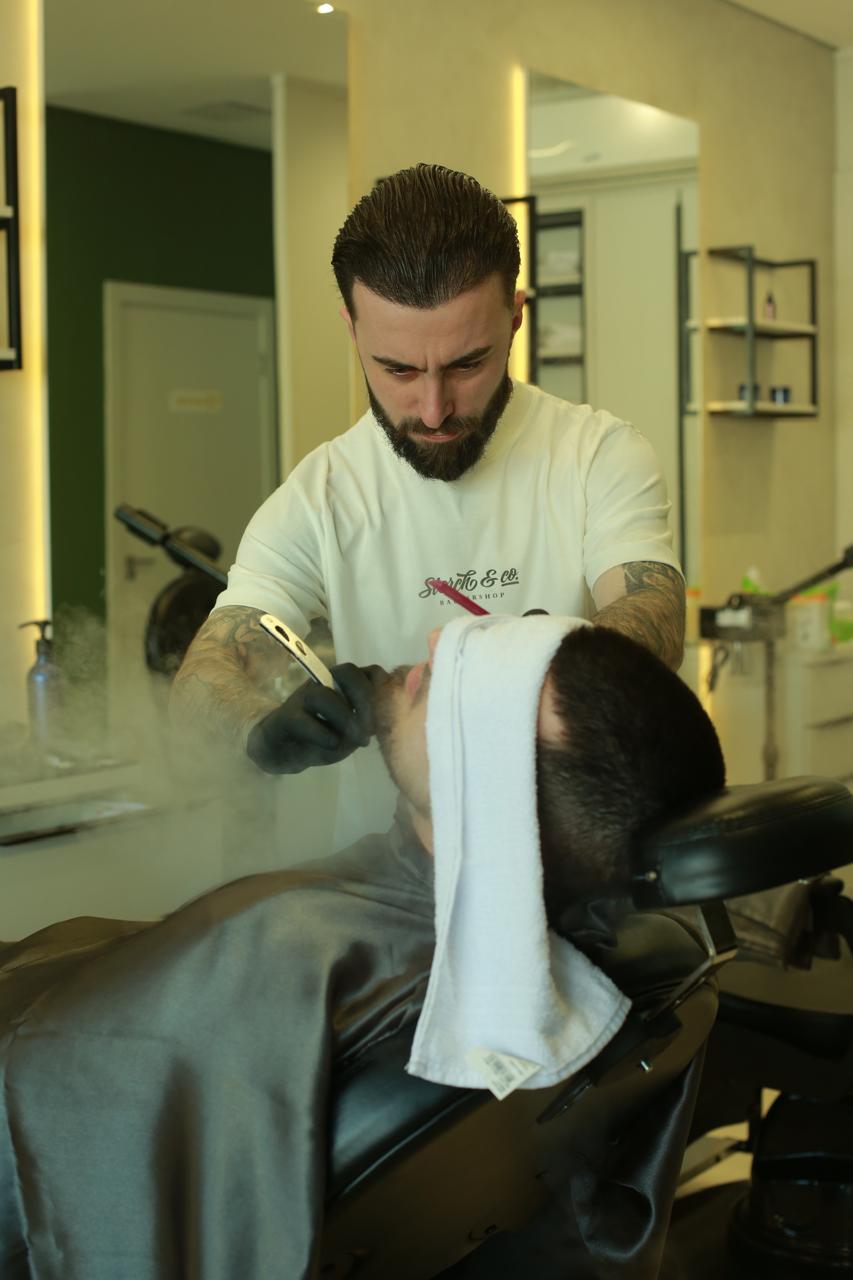 Barbeiro fazendo barba com navalha na Storch & Co.